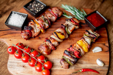 Meat kebabs with grilled vegetables on a rustic background