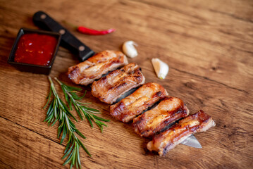 grilled pork ribs on a knife on a wooden background