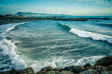 Olas de mar con escollaje de fondo