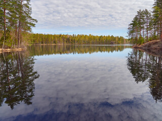 Lake Fisktrask in Finnish Sipoo: spring, may, sunny, cloudy sky reflection in lake, nature of the nordic countries.