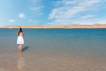 Egypt: girl with smartphone in blue lake water in Ras Mohammed National Park
