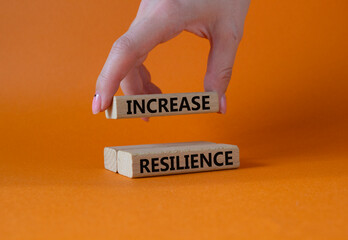 Increase resilience symbol. Wooden blocks with words Increase resilience. Businessman hand....