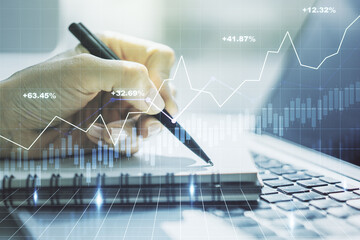 Abstract creative financial graph with hand writing in notebook on background, forex and investment concept. Multiexposure