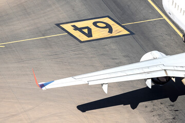 Fototapeta na wymiar Ala de un avión comercial sobre la pista de aterrizaje en el aeropuerto de Málaga,España