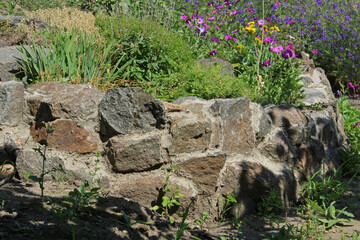 Landscaping. The flower bed is made of large stones. Flowerbed with flowers.