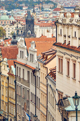 Facades of historical buildings with tile roofs in downtown of Prague.