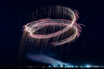 Two gliders during night air show releasing fireworks and paint serpentines in the night sky. - obrazy, fototapety, plakaty