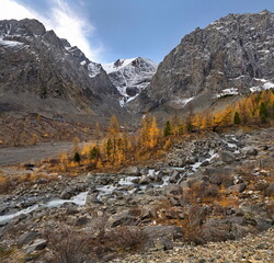Fototapeta na wymiar Russia. The South of Western Siberia, the Altai Mountains. Autumn view of the valley of the Aktru River, the source of which is located at the foot of the glacier on the North Chui mountain range.