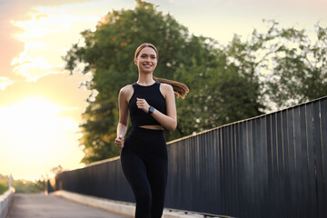 Attractive sporty woman in fitness clothes jogging outdoors