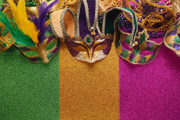 Mardi gras, Venetian or Carnivale mask on on a tricolor shining background.