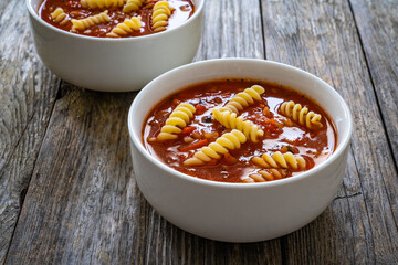 Tomato soup with noodles on wooden table
