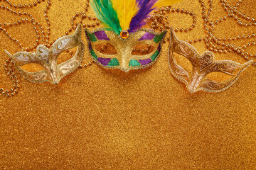 Fototapeta na wymiar Mardi gras or carnival mask with beads on gold glowing background. Venetian mask.