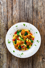 Pasta with roasted pork loin, spinach and parmesan on wooden table 