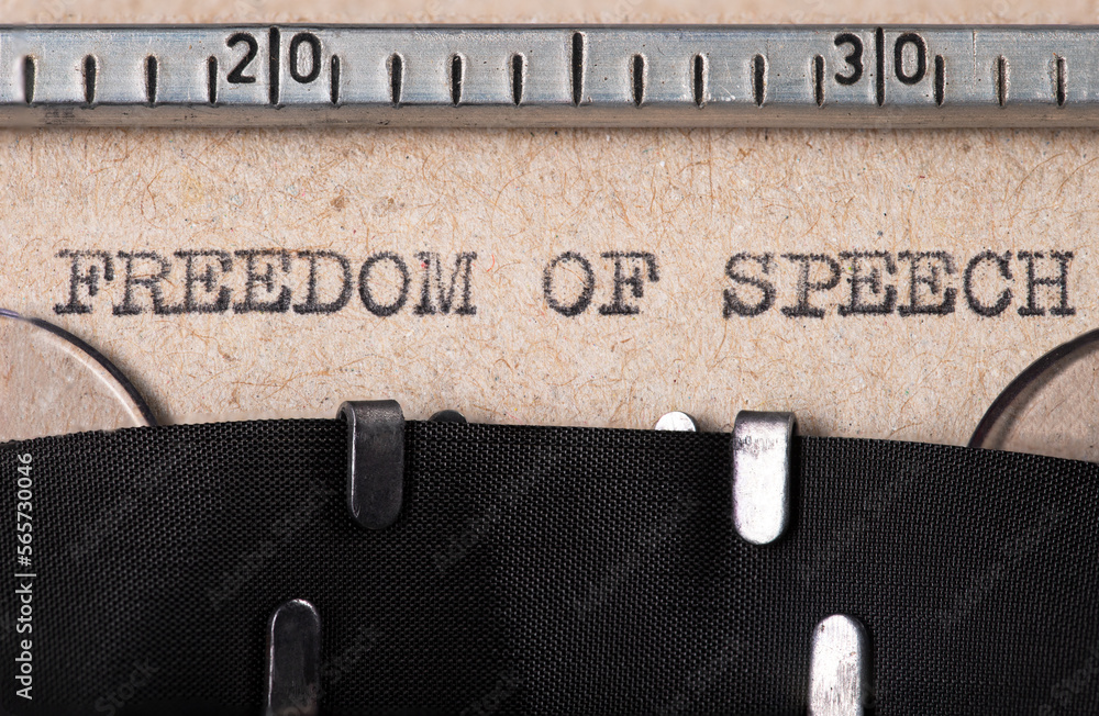 Fototapete the word 'feedom of speech' embossed on gray paper using an old typewriter.