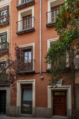 Fototapeta na wymiar Brick facades of a narrow old building in a pedestrian street in the center of Madrid in the Barrio de las Letras