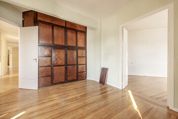 Empty living room with beautiful oak parquet floors and custom made antique cabinet