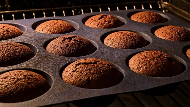 Chocolate muffins. Baking in oven. Time lapse footage of cooking brown cupcakes. Homemade bakery concept. Growing cupcakes. Close-up in 4k, UHD