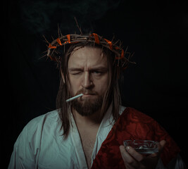 Jesus Christ smokes a cigarette wearing a crown of thorns and white chiton toga cape himation...