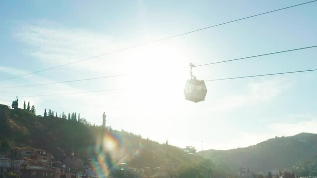 Cable car trip. During the trip by cable car Tourists enjoy beautiful views and experience exciting. Aerial view of Georgia, Tbilisi, Peace Bridge, Concert Music Theatre, river Kura and Cable car.