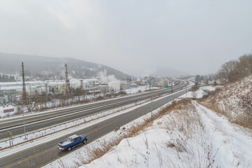 Obraz premium Mountain town highway road and oil plant during snow weather, travel USA town