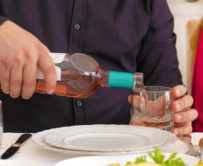 Young man pouring wine from the bottle into a glass . wine at restaurant. High quality photo