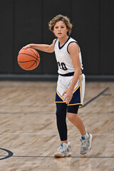 Young boy playing in a competitive youth basketball game