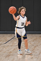 Young boy playing in a competitive youth basketball game