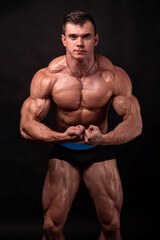 Fototapeta na wymiar Muscled Man Showcases Toned Body in Studio