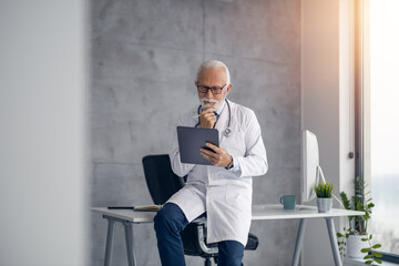 Shot of senior male doctor working online consultation