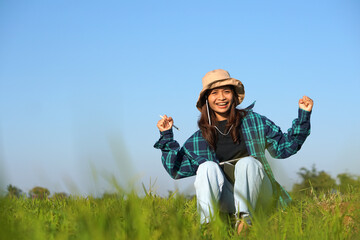 Asian female farmer delighted with rice growth target. Computer analysis