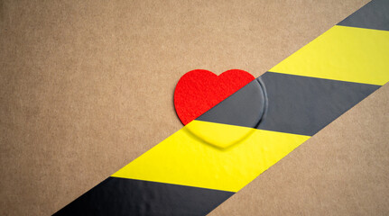 A red heart made of fabric sealed with sticky tape. The end of love.Anti romantic picture. The prohibition of Valentine's Day.