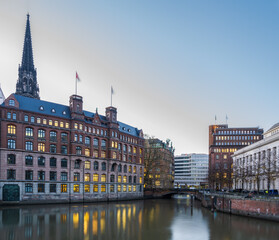 Historic and modern buildings at dusk with light reflection on the canal in Hamburg, Germany