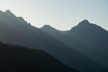 Sun pouring through mountain silhouette 