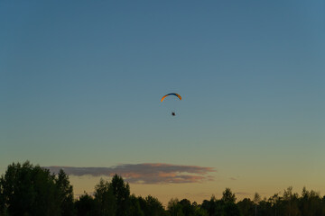 paragliding training silhouette of a paraglider in the air against the background of the evening...