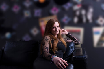 Fototapeta na wymiar blonde young woman sitting on a black sofa