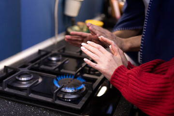 Freezing couple warming close to gas oven. Cold winter and high price taxes concept