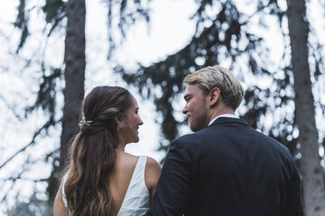 Back view of a Bride and Groom in a forest during winter. High quality photo