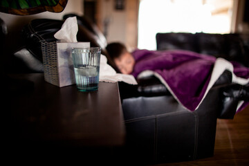 Side angle shot of blurred out sick boy on couch