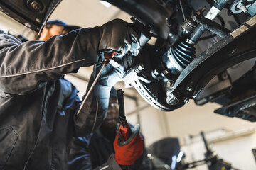 Fototapeta na wymiar Mechanic replacing car wheels using different modern tools in a car repair station. High-quality photo