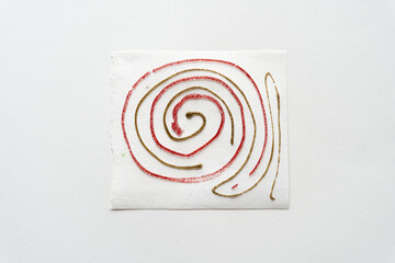 freehand coil or spiral in red and gold glitter material