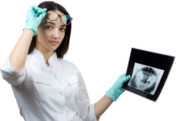 Girl dentist in a white coat holds a snapshot of the patient's teeth.