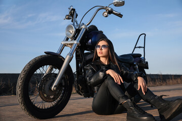 Fototapeta na wymiar Beautiful woman sitting near motorcycle on sunny day