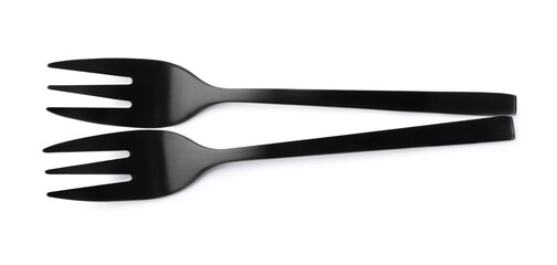 New black dessert forks on white background, top view