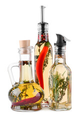 Different sorts of cooking oil with spices and herbs in bottles on white background