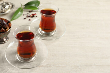 Glasses of tea and vintage tea set on wooden table, space for text