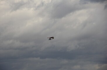 曇った空を飛んでいる軽飛行機
