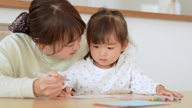 お絵描きをして遊ぶ女の子とお母さん