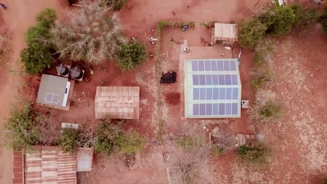 Aerial view of a village in Africa with a house with a solar panel on the roof. Development aid africa.
