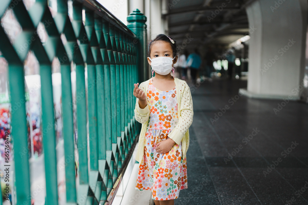 Wall mural Small girl in healthy face mask