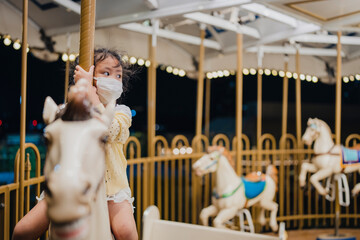Small girl carousel horse in the park © tienuskin